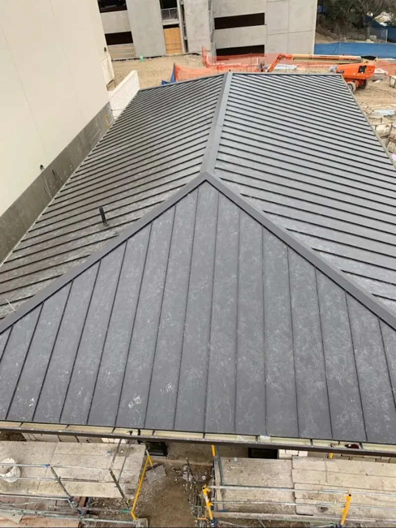 Commercial metal roof construction with crane equipment in Linda